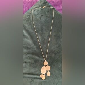 Gold tone drop necklace with dangling brushed metal teardrops and circles.